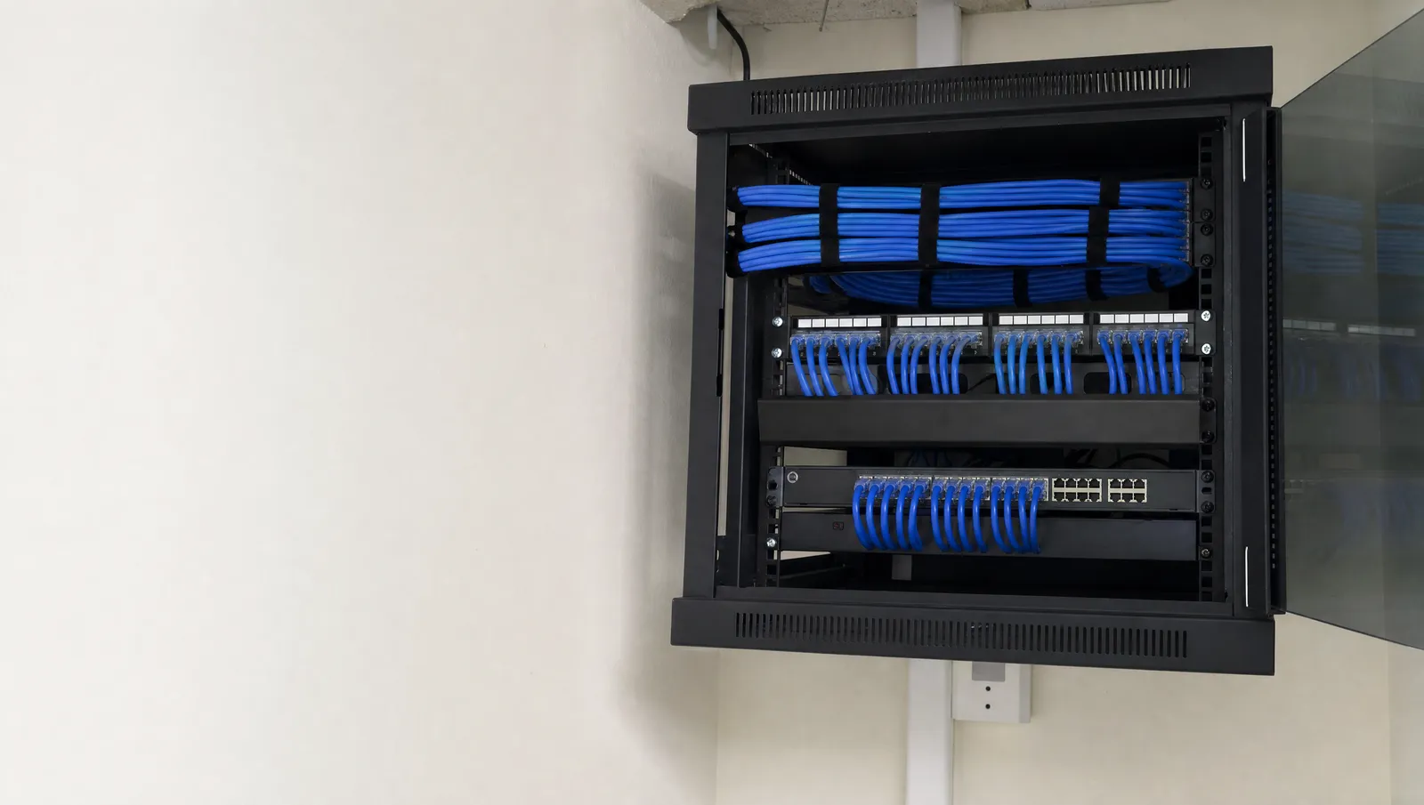 Gabinete de red con cables azules ordenados y etiquetas blancas